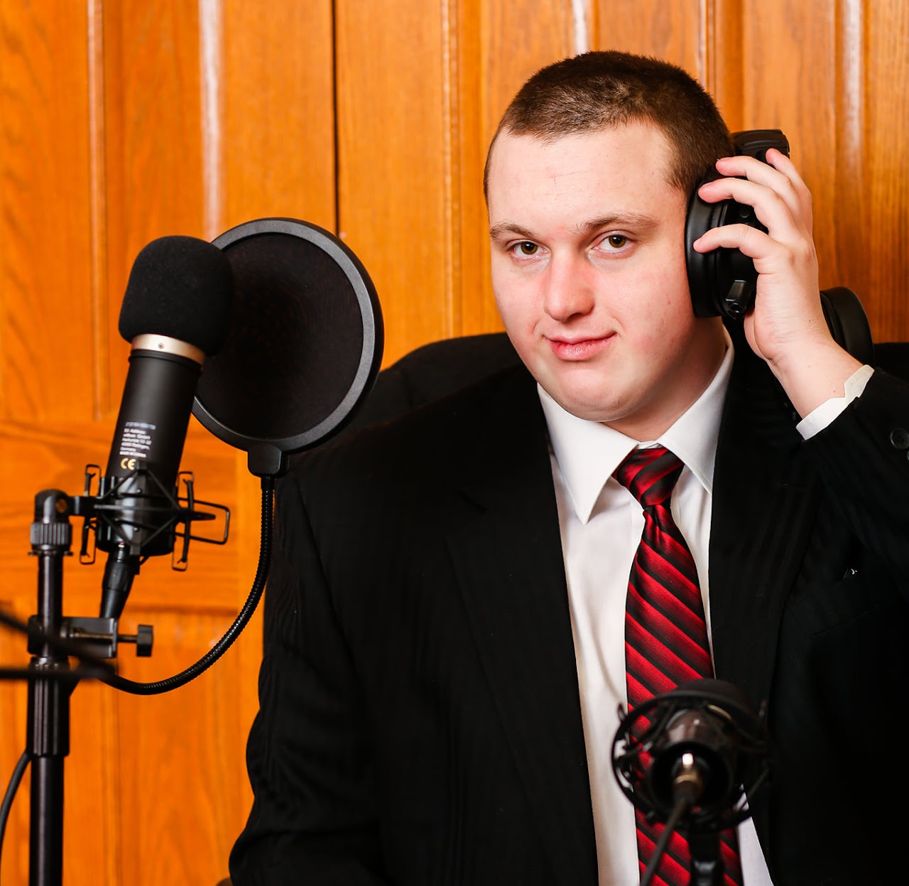Sam Mitchell, founder and CEO of Autism Rocks and Rolls, in headphones at a podcast microphone